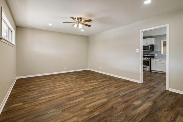 spare room with dark hardwood / wood-style floors and ceiling fan