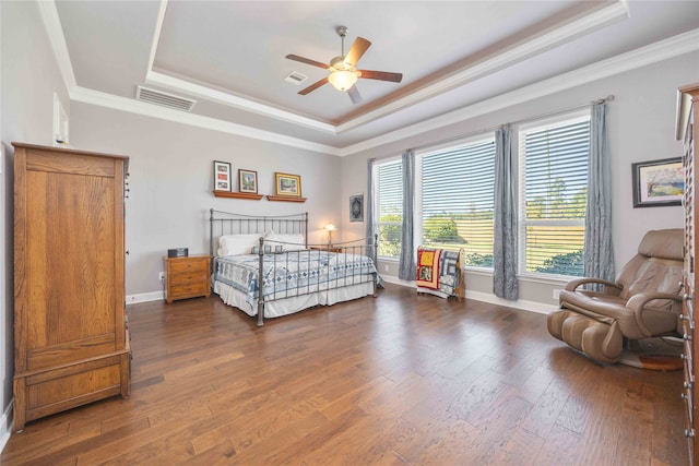 bedroom with ceiling fan, dark hardwood / wood-style flooring, and a tray ceiling