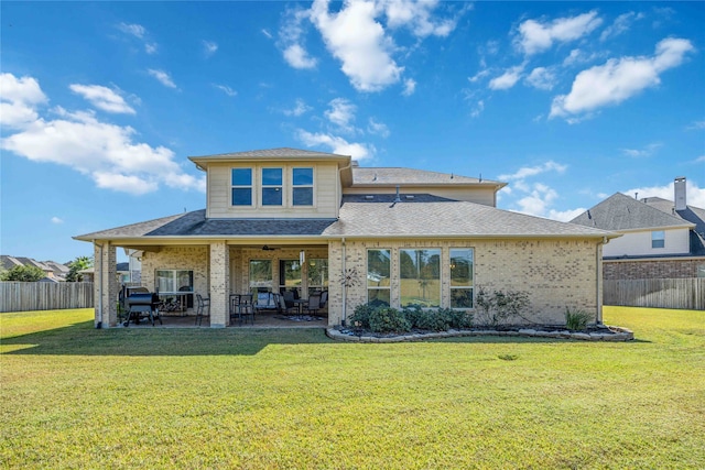 back of property featuring a lawn and a patio