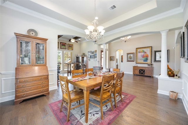 dining area featuring dark hardwood / wood-style flooring, crown molding, ornate columns, and ceiling fan with notable chandelier