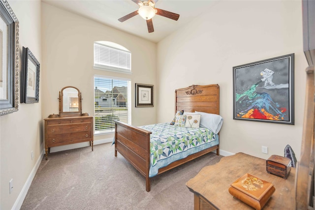 bedroom with light colored carpet, ceiling fan, and a high ceiling