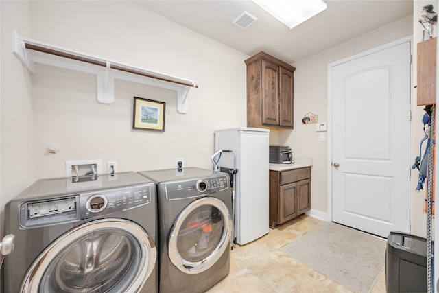 laundry room featuring washing machine and dryer and cabinets