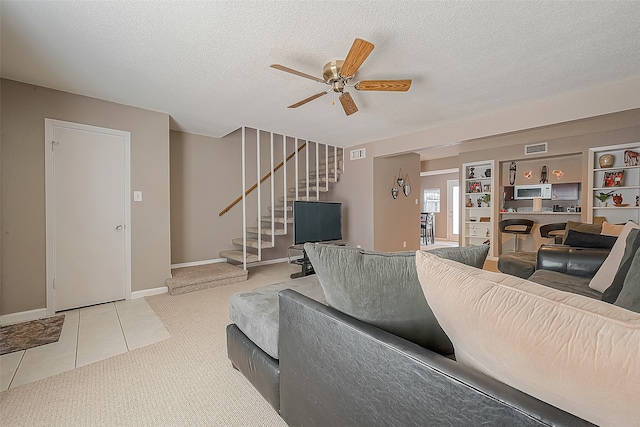 carpeted living room featuring a textured ceiling and ceiling fan