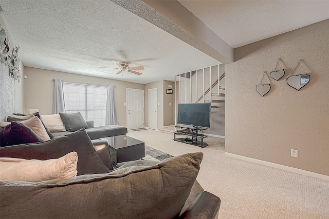 living room featuring a textured ceiling, light colored carpet, and ceiling fan