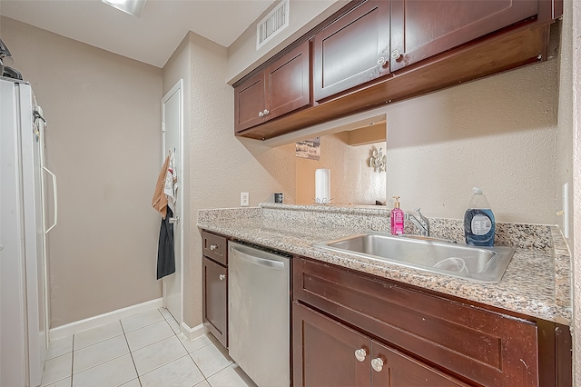 kitchen featuring light tile patterned flooring, white refrigerator, light stone countertops, sink, and stainless steel dishwasher