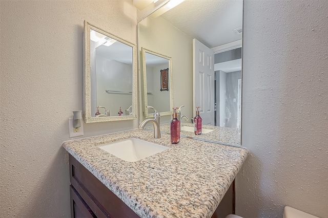 bathroom with vanity and a textured ceiling