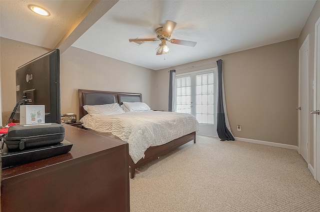 bedroom with a textured ceiling, french doors, light colored carpet, and ceiling fan