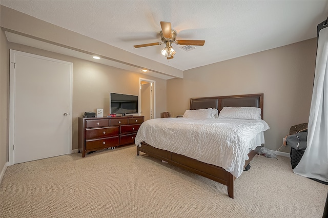 bedroom with a textured ceiling, light carpet, and ceiling fan