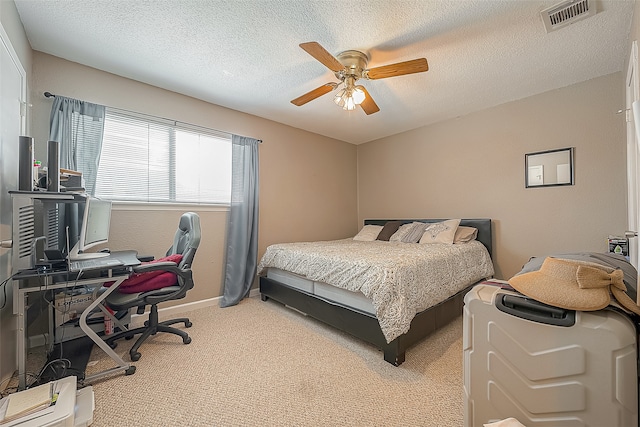 bedroom with a textured ceiling, light carpet, and ceiling fan