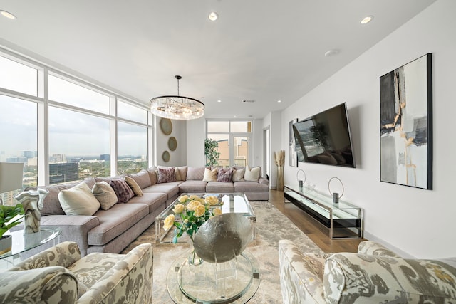 living room featuring hardwood / wood-style floors, a wall of windows, and an inviting chandelier