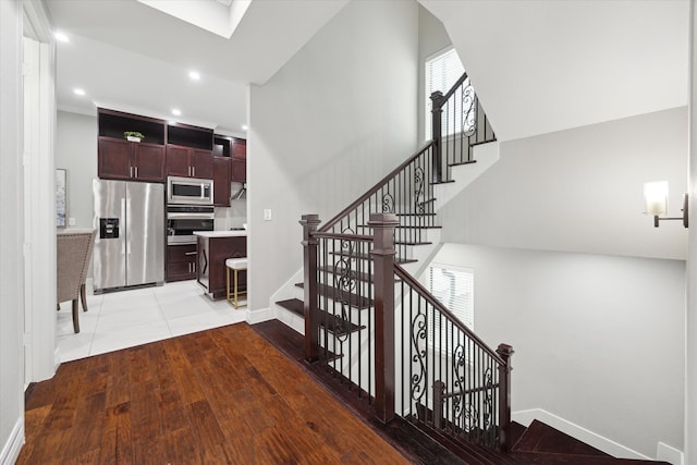 stairs with a skylight and wood-type flooring