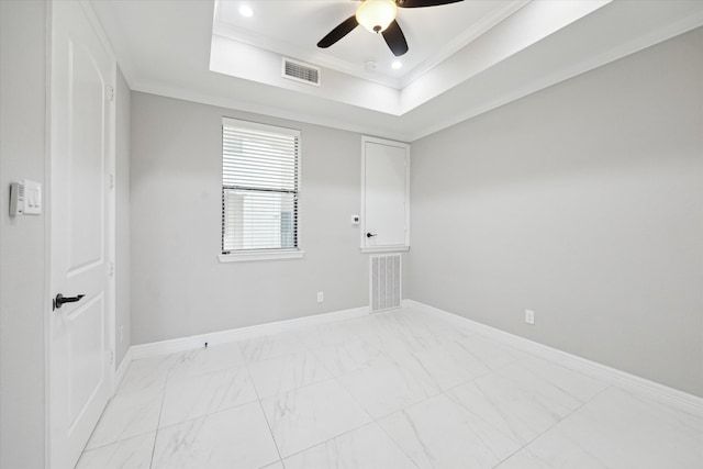 unfurnished room with a raised ceiling, ceiling fan, and ornamental molding