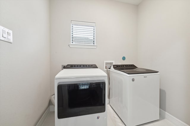 laundry room featuring washing machine and clothes dryer and light tile patterned floors