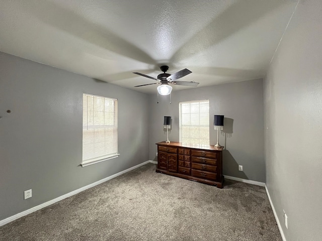 carpeted bedroom featuring ceiling fan and a textured ceiling