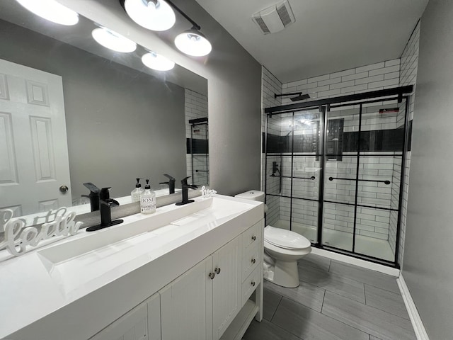 bathroom with walk in shower, vanity, and toilet