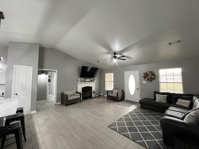 living room featuring ceiling fan, wood-type flooring, and vaulted ceiling