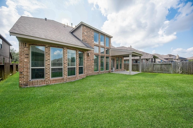 back of property with a patio area and a yard