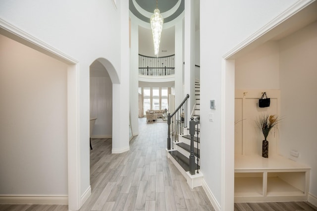 entryway featuring a towering ceiling and light hardwood / wood-style floors