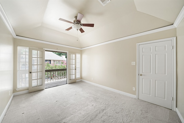 carpeted spare room with ceiling fan, a raised ceiling, vaulted ceiling, and ornamental molding