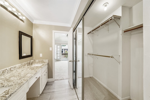 bathroom featuring ceiling fan, vanity, and ornamental molding