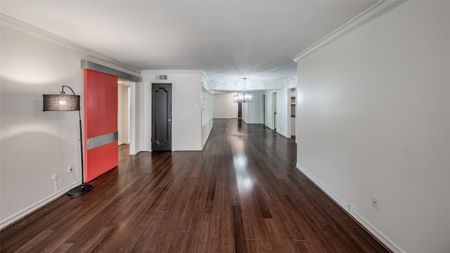 empty room with a chandelier, dark hardwood / wood-style flooring, and ornamental molding