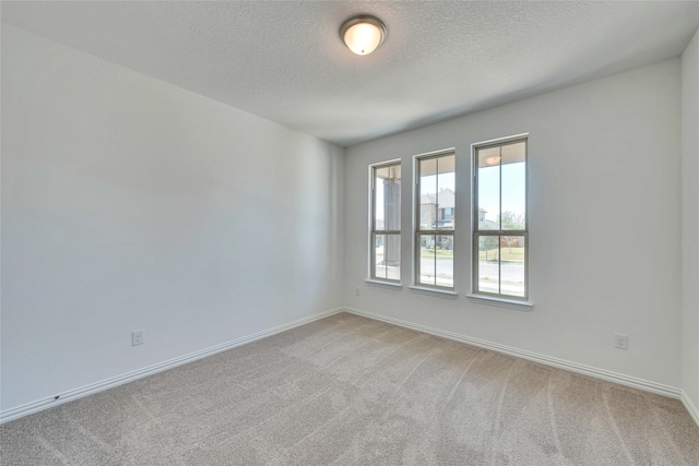 carpeted spare room with a textured ceiling