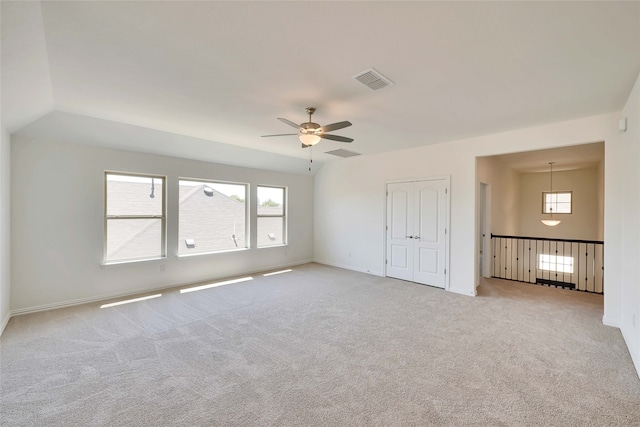 carpeted spare room with ceiling fan and lofted ceiling