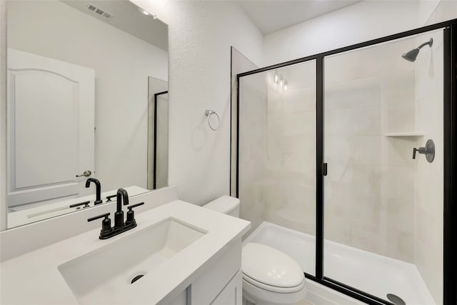 bathroom featuring vanity, toilet, and walk in shower