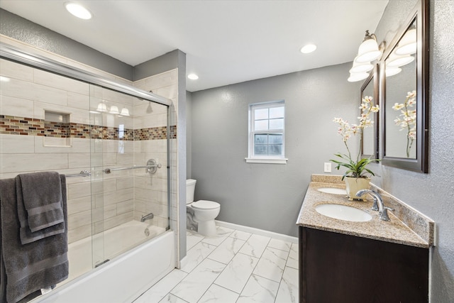 full bathroom with bath / shower combo with glass door, vanity, and toilet