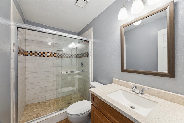 bathroom with walk in shower, vanity, a textured ceiling, and toilet