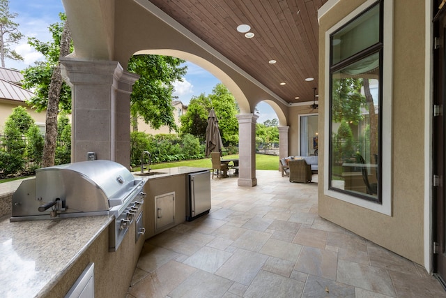 view of patio featuring an outdoor hangout area, exterior kitchen, sink, and grilling area