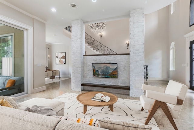 living room featuring decorative columns, crown molding, and a healthy amount of sunlight