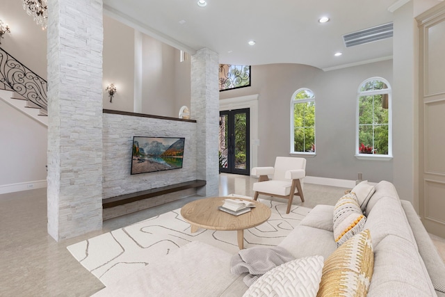 living room featuring ornate columns, crown molding, and french doors