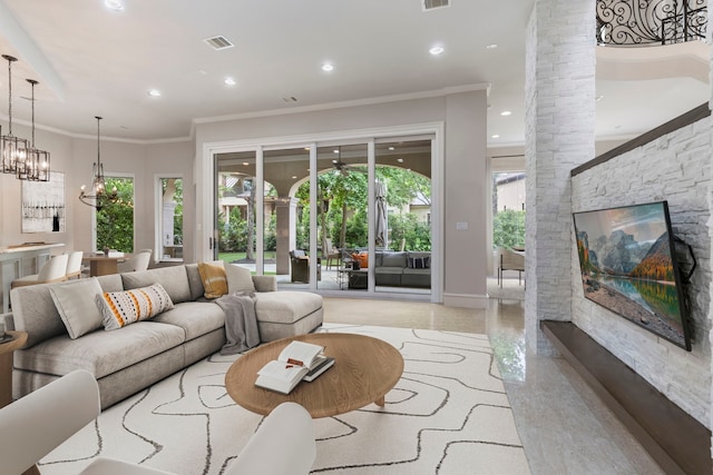 living room with a fireplace, crown molding, and a chandelier