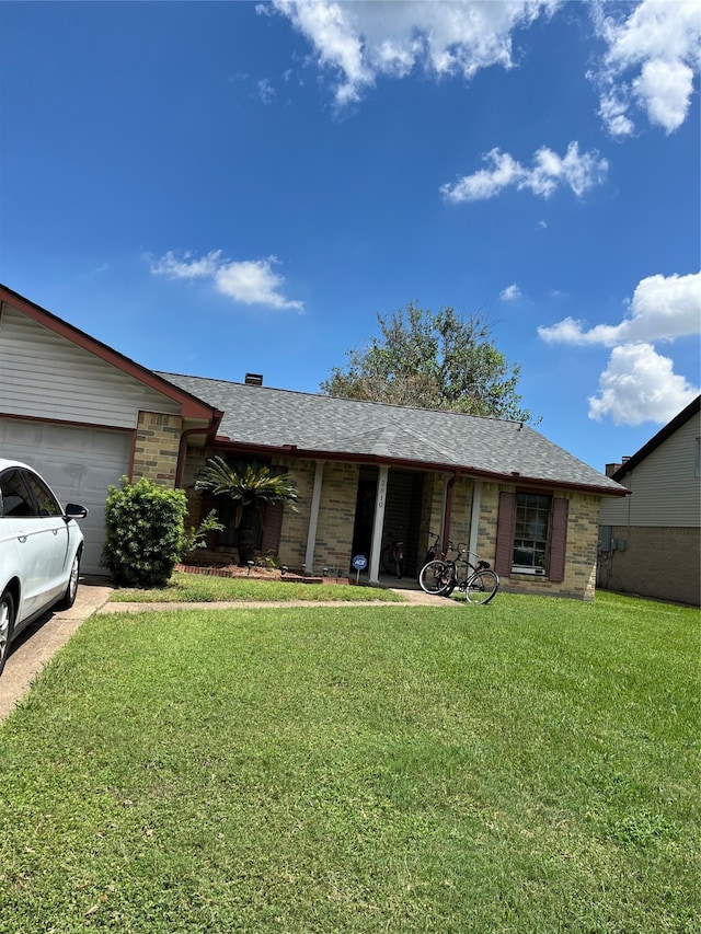 single story home featuring a garage and a front lawn