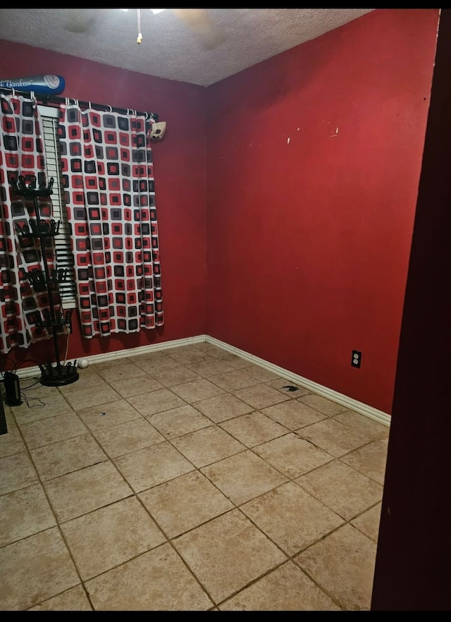 empty room with tile patterned flooring and a textured ceiling