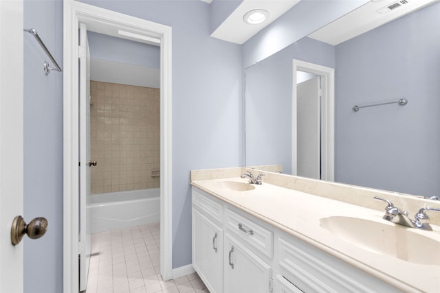 bathroom featuring tiled shower / bath combo, vanity, and tile patterned flooring