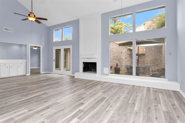 unfurnished living room featuring a towering ceiling and a healthy amount of sunlight