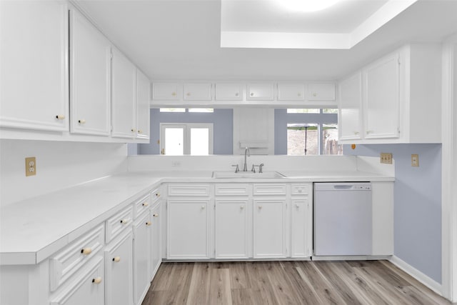 kitchen with light hardwood / wood-style floors, white cabinetry, sink, and dishwasher