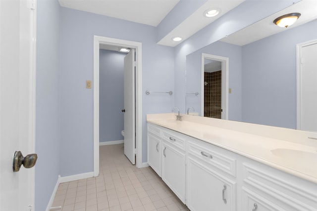 bathroom with tile patterned flooring, vanity, and toilet