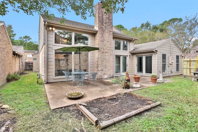 rear view of house featuring a patio and a yard