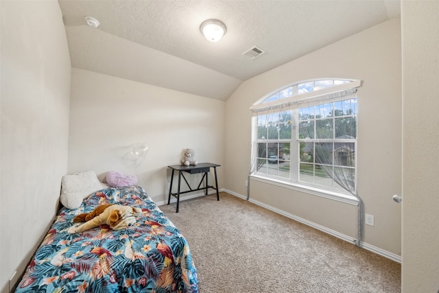 carpeted bedroom with lofted ceiling and a textured ceiling