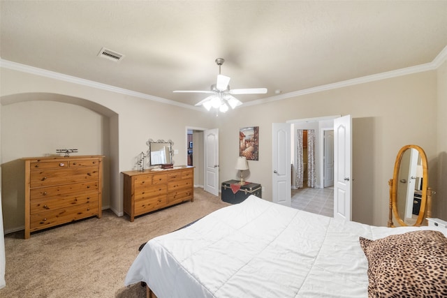 carpeted bedroom featuring ceiling fan and crown molding