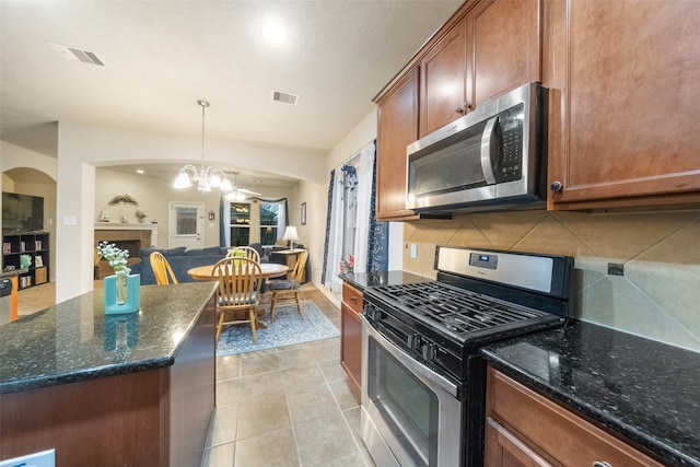 kitchen featuring a notable chandelier, light tile patterned floors, tasteful backsplash, appliances with stainless steel finishes, and decorative light fixtures