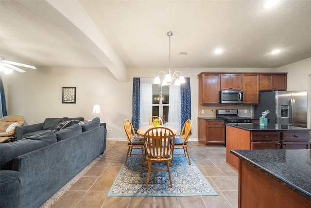 kitchen featuring beamed ceiling, appliances with stainless steel finishes, ceiling fan with notable chandelier, light tile patterned floors, and decorative light fixtures