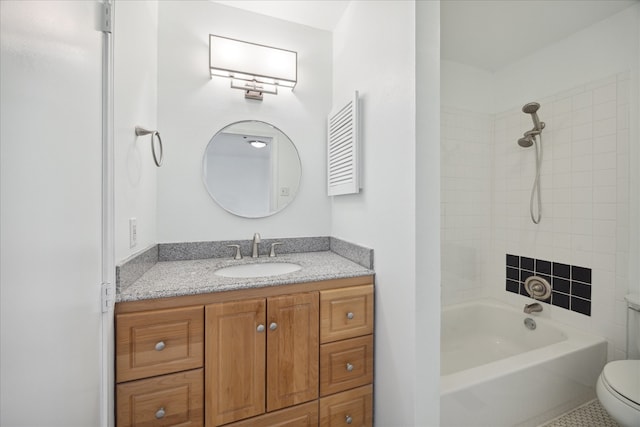 full bathroom with tile patterned floors, vanity, tiled shower / bath combo, and toilet