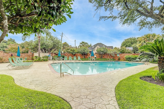 view of pool featuring a patio and a lawn