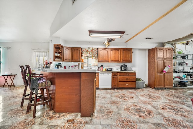 kitchen featuring lofted ceiling, white dishwasher, and a breakfast bar area