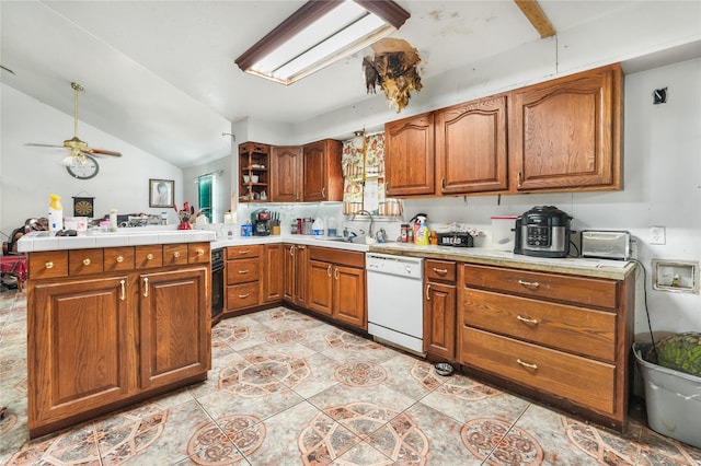 kitchen featuring ceiling fan, dishwasher, sink, kitchen peninsula, and vaulted ceiling