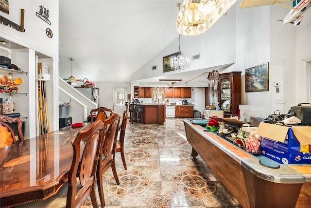 dining area featuring a notable chandelier and high vaulted ceiling